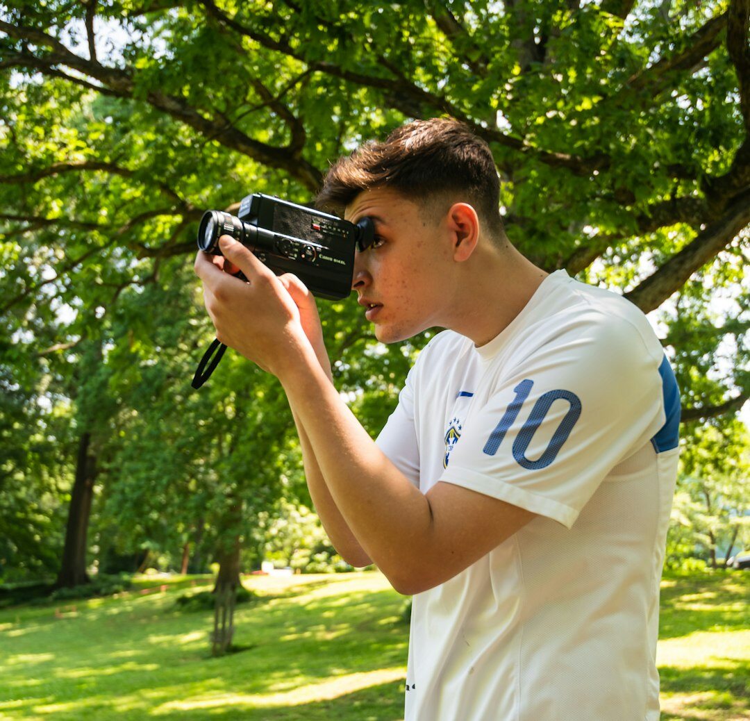Finnish male student wearing headphones practicing camera operation